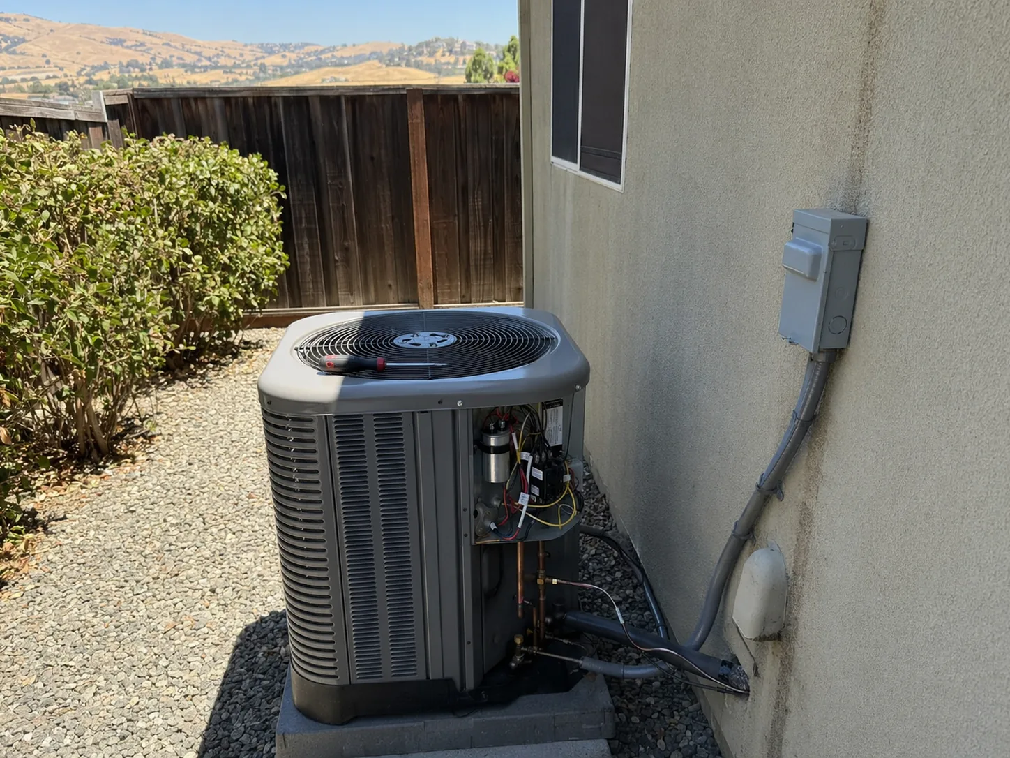 New residential AC condenser installed beside a home in Livermore, Bay Area